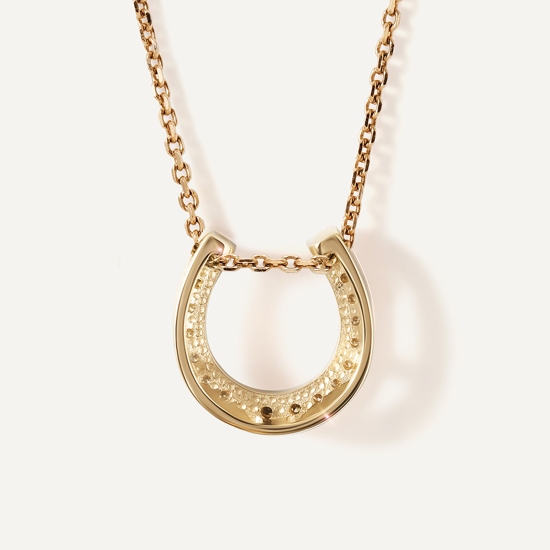 Подвеска из желтого золота с зелеными бриллиантами "Подкова"