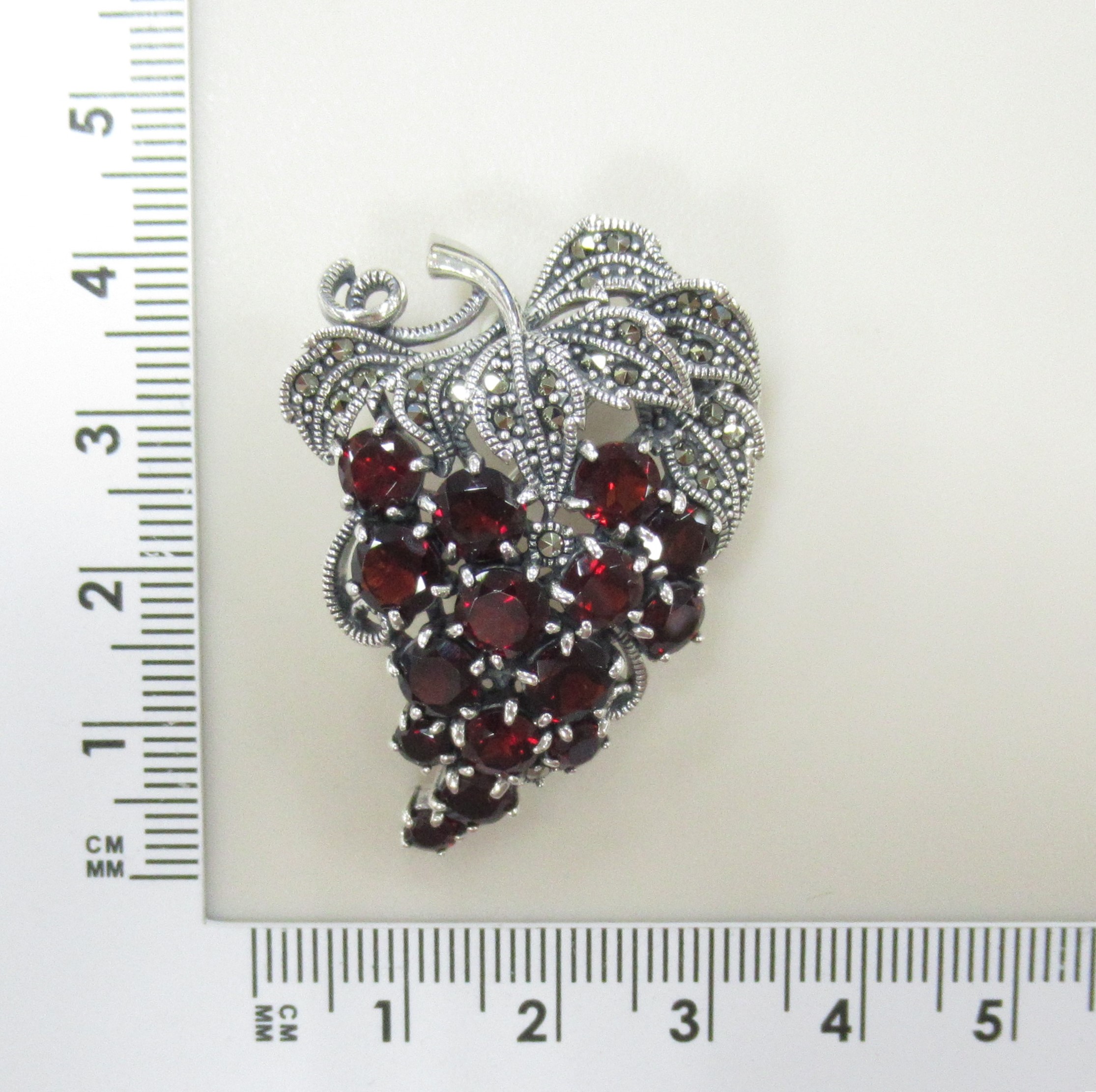 Серебряная брошь-подвеска 925 пробы; оксидирование; вставки 15 Гранат; 29 Марказит;